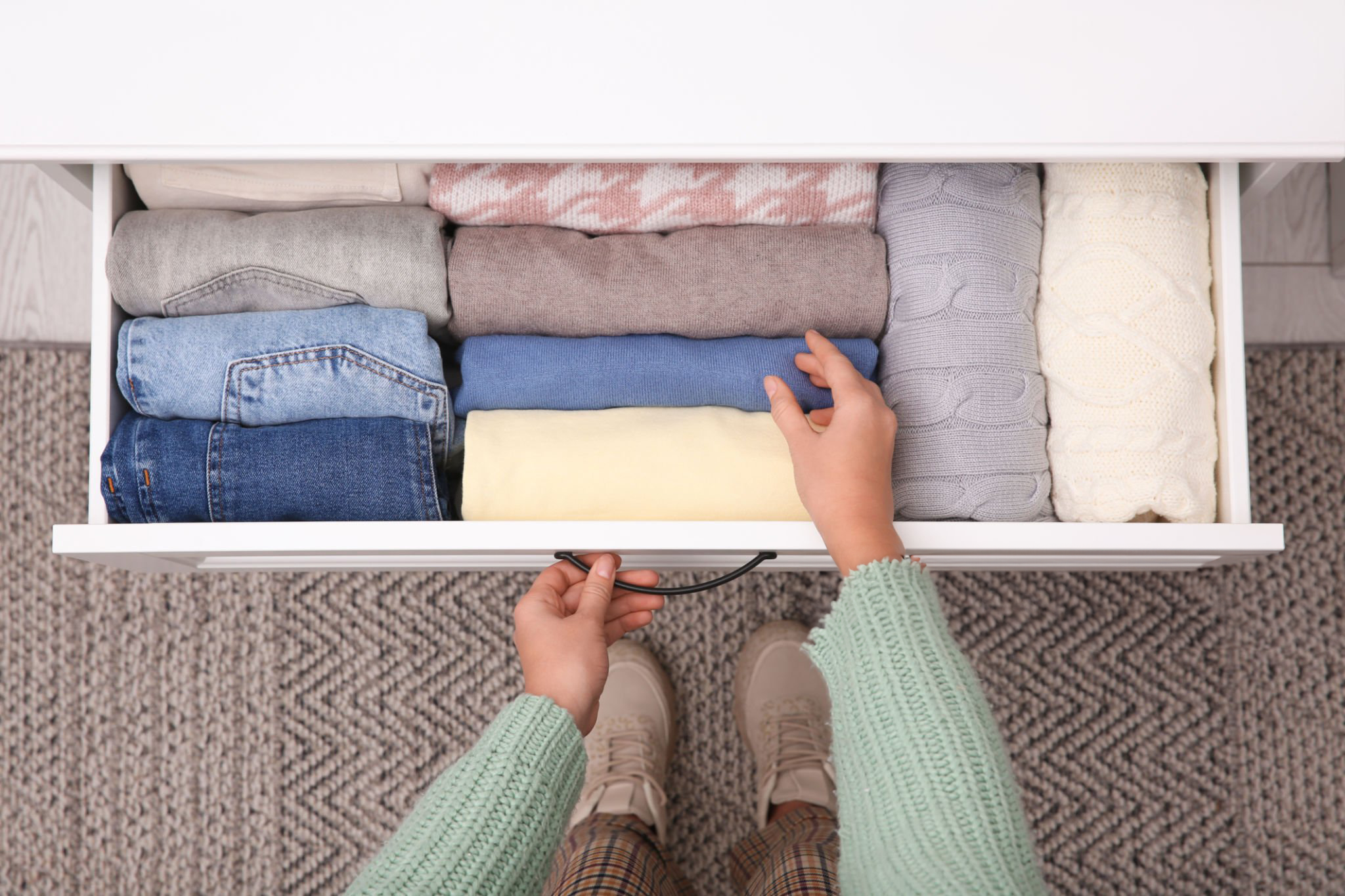 Putting folded clothes into a drawer