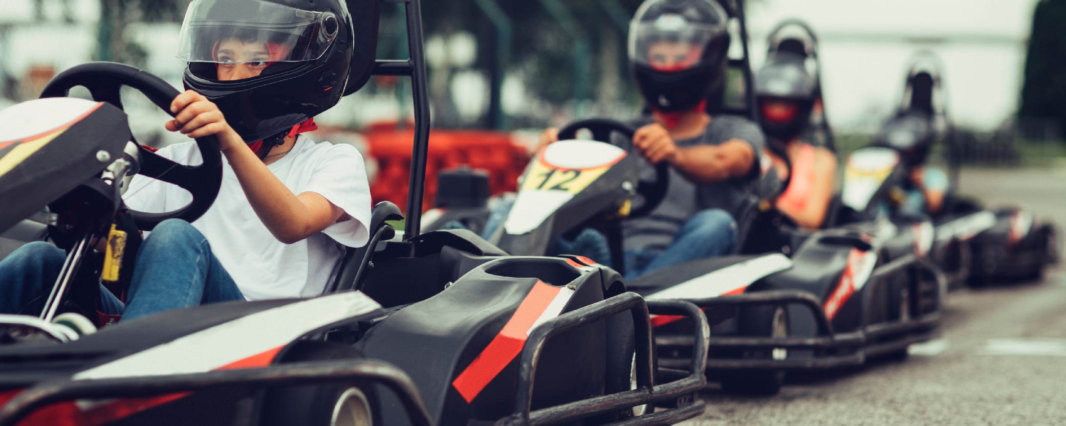 Children ride go-karts on an indoor track