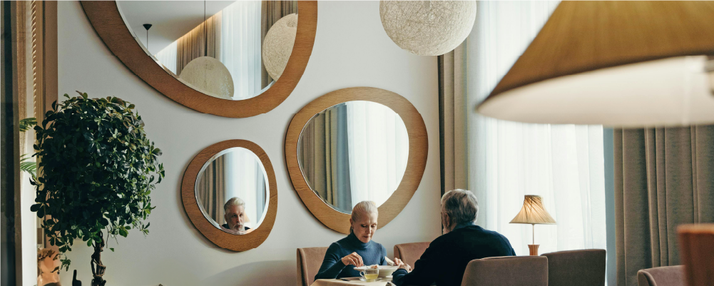 A wall with various sized mirrors hung